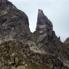 Surowe, skaliste zbocza Tatr poza szlakiem, z ostrym szczytem dominującym nad krajobrazem.