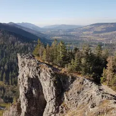 Widok z urwiska na Tatry i Zakopane. Ścieżka prowadzi przez las, pokazując, jak dojść na Nosal z Zakopanego.