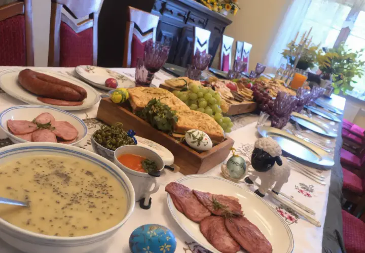 Uczta w gazdówce: bieszczadzkie smaki, kiełbasa, zupa, wędliny, winogrona i wielkanocne pisanki.