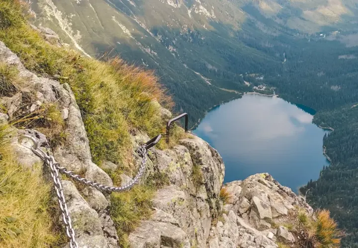 Łańcuchy ułatwiają przejście przez skalistą przełęcz pod Chłopkiem, z widokiem na jezioro Morskie Oko.