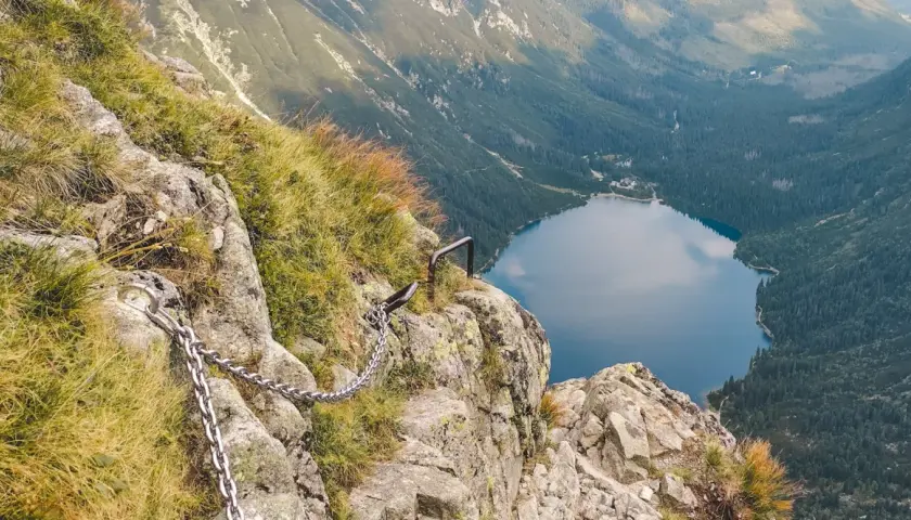 Łańcuchy ułatwiają przejście przez skalistą przełęcz pod Chłopkiem, z widokiem na jezioro Morskie Oko.