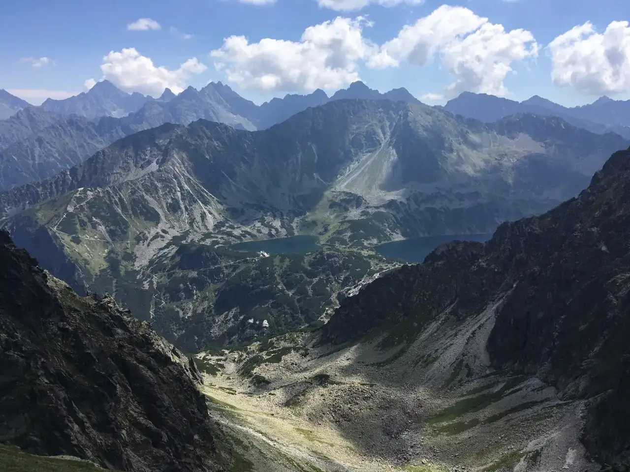 Widok na Tatry z pociągu, idealne miejsce, gdzie w góry z Poznania pociągiem. Jeziora i szczyty w słońcu.