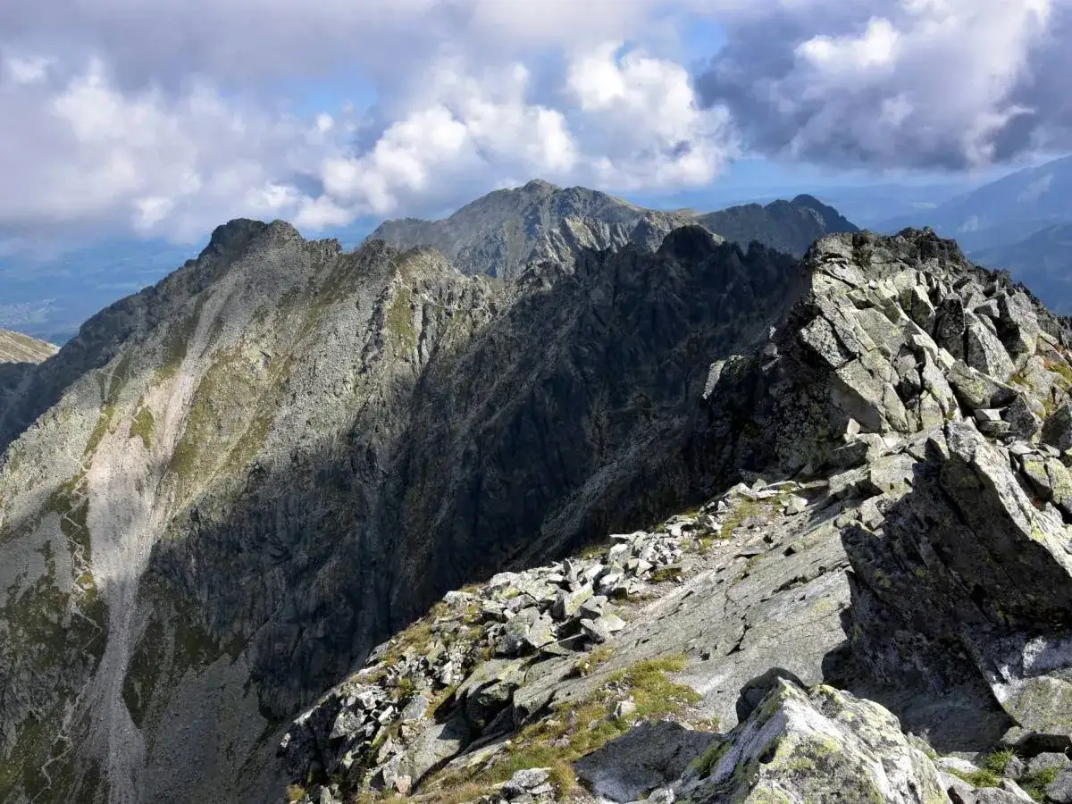 Kamieniste tatry wysokie szlaki wiją się między skalnymi graniami. Chmury na niebie dodają dramatyzmu krajobrazowi.