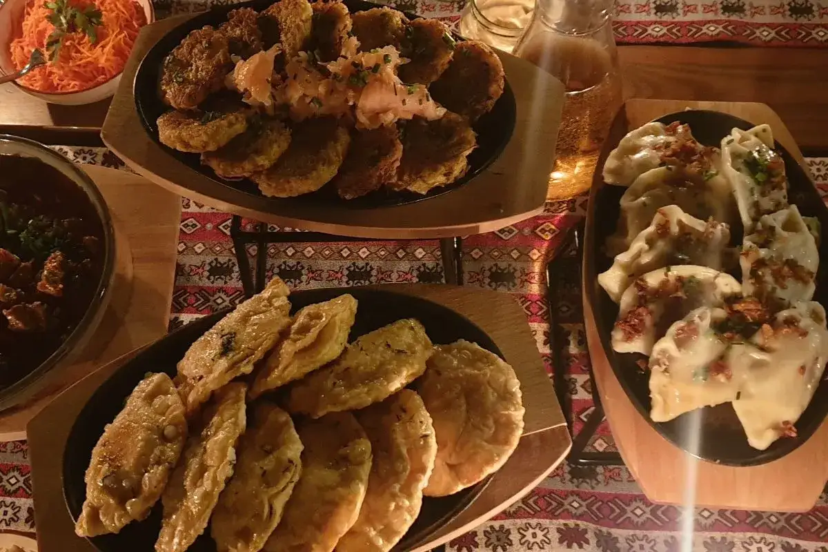 Bieszczadzkie smaki: placki ziemniaczane, pierogi i inne przysmaki na stole.