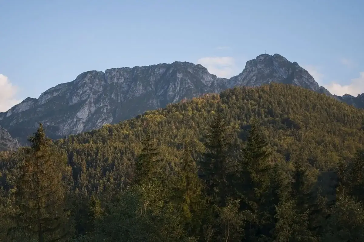 Górski krajobraz z lasem i skalistymi szczytami, gdzie według legendy znajduje się jaskinia śpiących rycerzy.