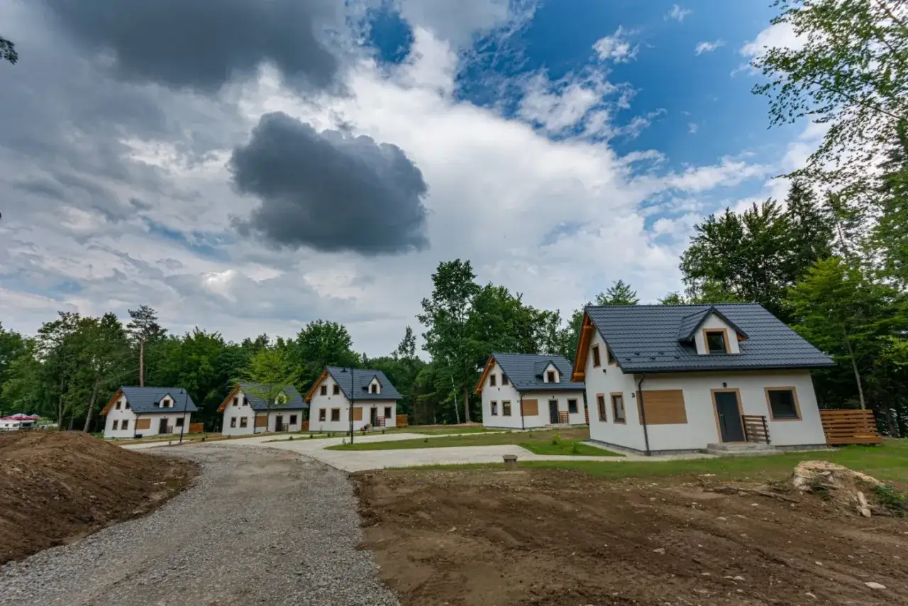 Nowe domki letniskowe w otoczeniu lasu, idealne na wypoczynek. To przystań, gdzie można naładować baterie, niczym na wyspie energetyk.