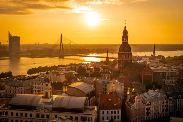 Zachód słońca nad Rygą. Widok na katedrę, most i nowoczesne budynki. Warto zobaczyć w Rydze to miasto pełne kontrastów.